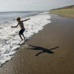 A boy jumps over a wave at Marconi Beach at the Cape Cod National Seashore.