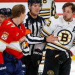 Refere Garrett Rank (7) separate Boston Bruins defenseman Charlie McAvoy (73) and Florida Panthers defenseman Niko Mikkola (77) during third period action in game two of the Eastern Conference NHL second round Playoff game at Amerant Bank Arena.